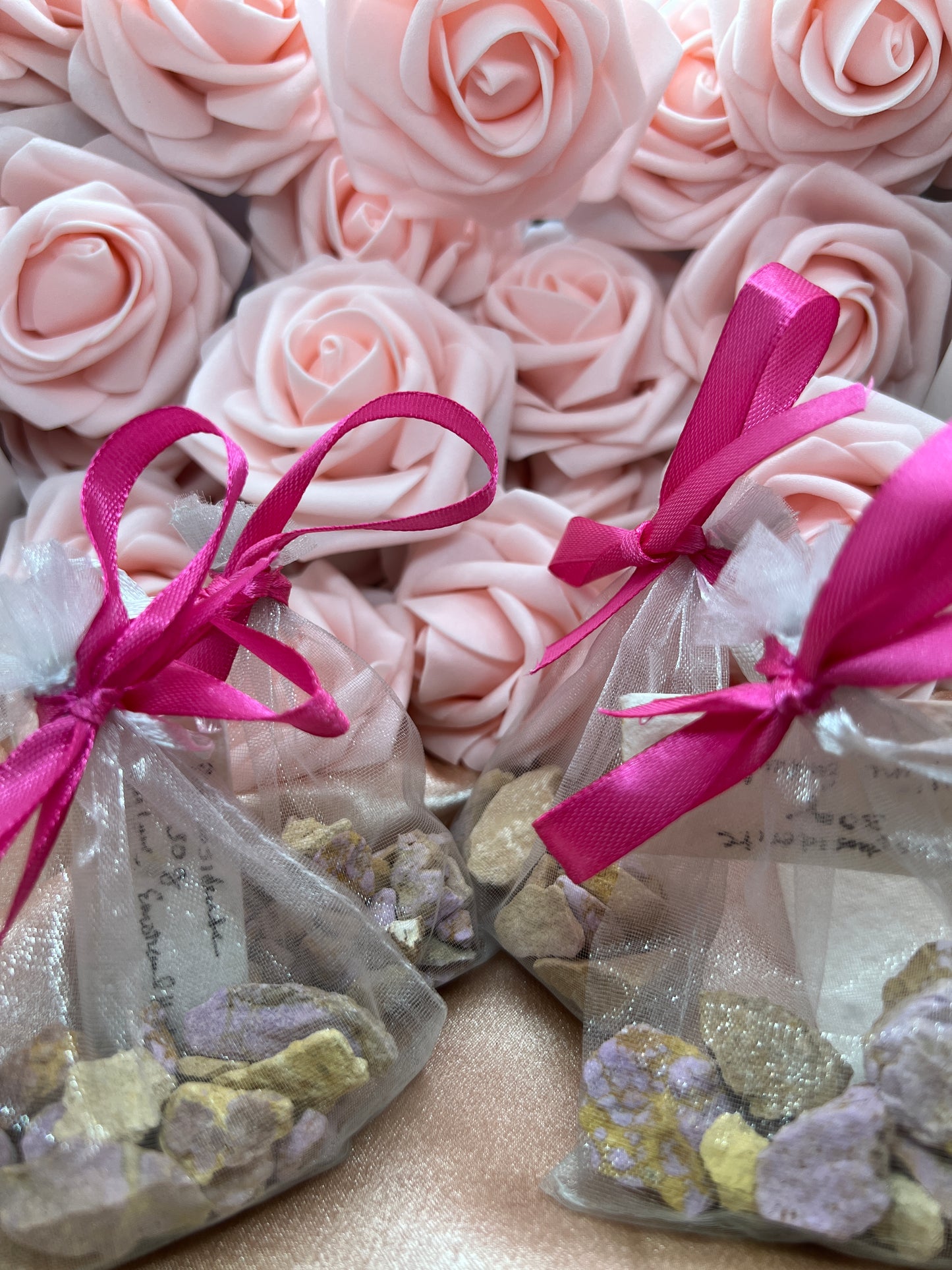 Pink roses with pink ribbons and decorative elements on a textured surface