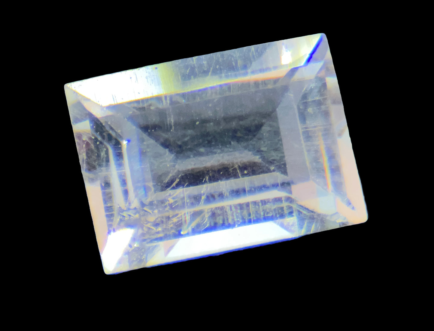 Rectangular crystal with rainbow-like color patterns on a black background