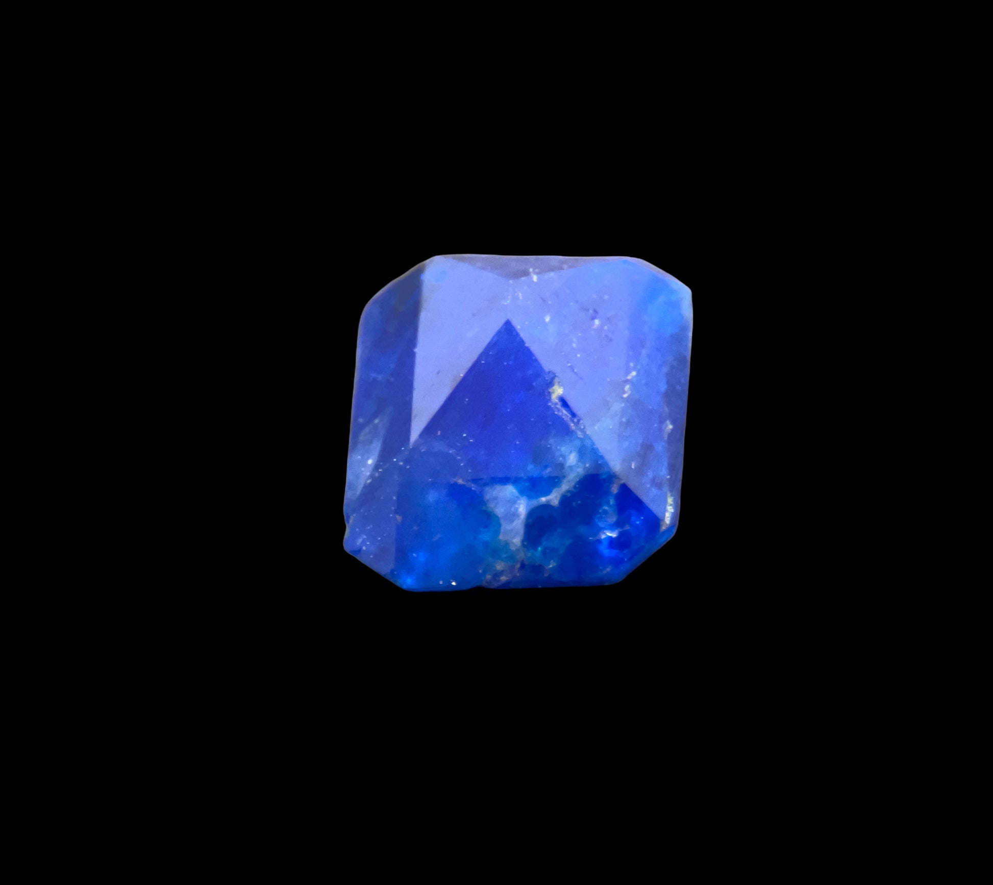 Faceted blue gemstone on a black background