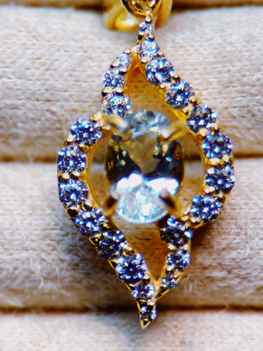 Gold pendant with blue gemstones on a wooden surface