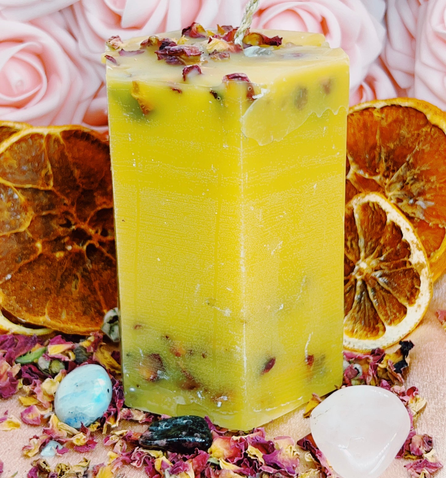 Beeswax Candle with natural ingredients on a decorative background with dried oranges and flowers.