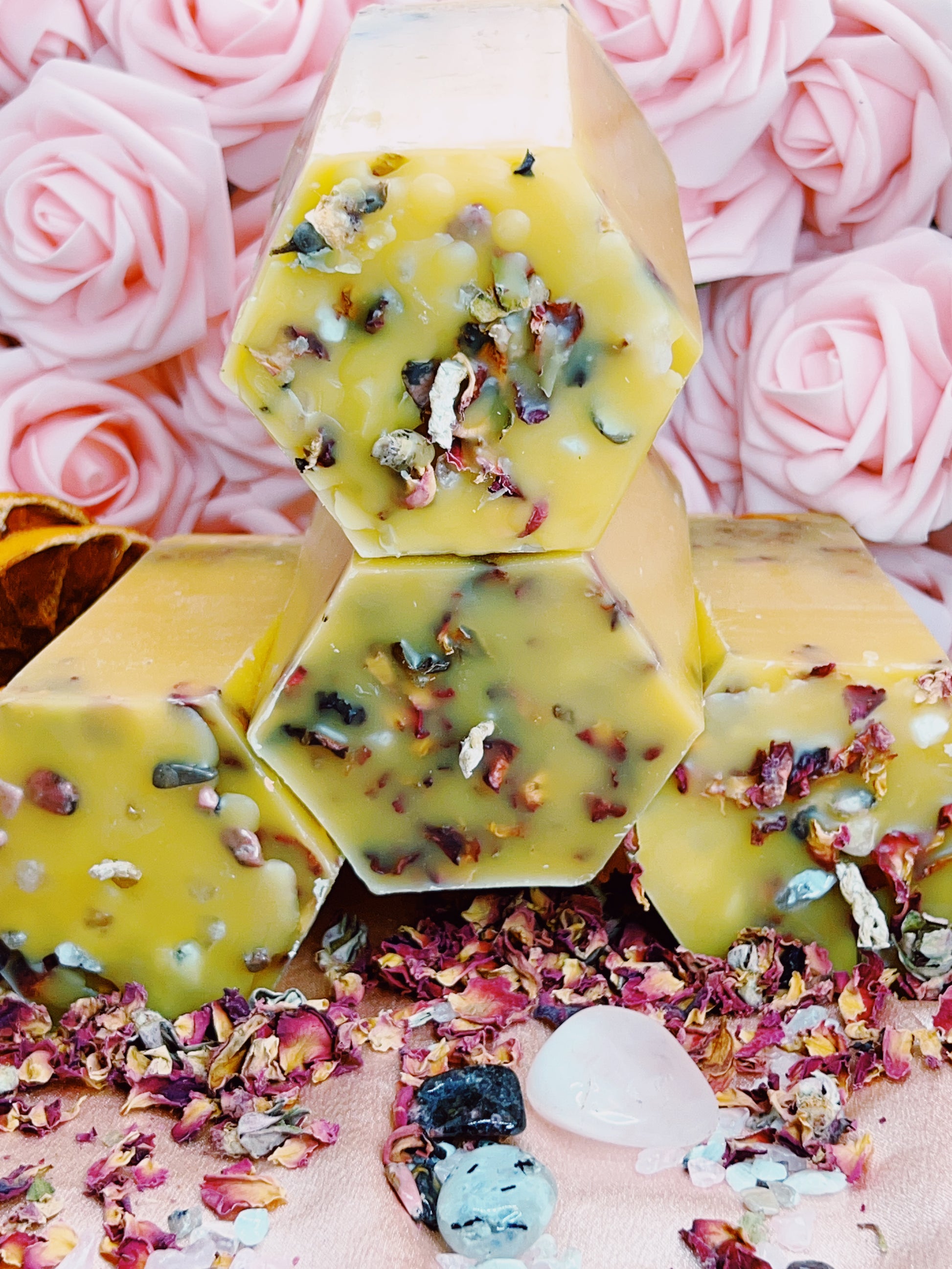 Hexagonal Beeswax Candles with dried flowers and petals on a pink floral background