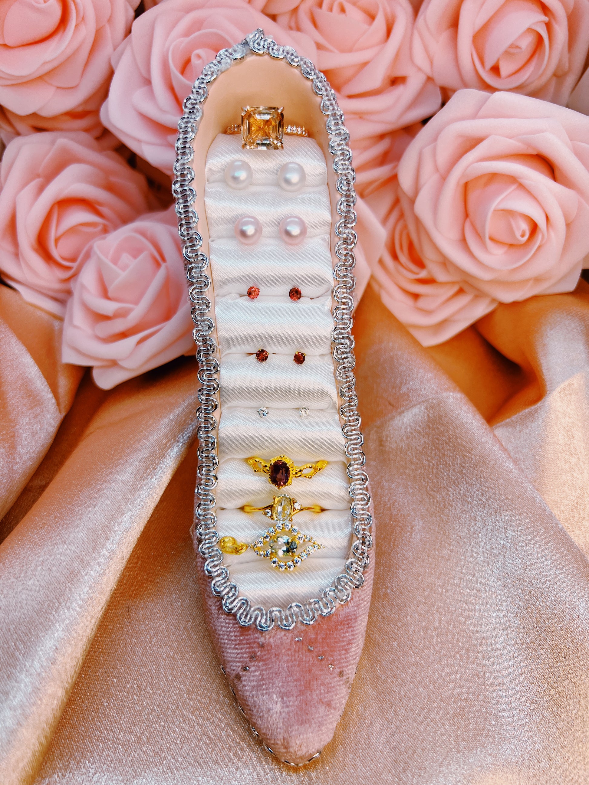 Decorative jewelry box with rings on a pink floral background