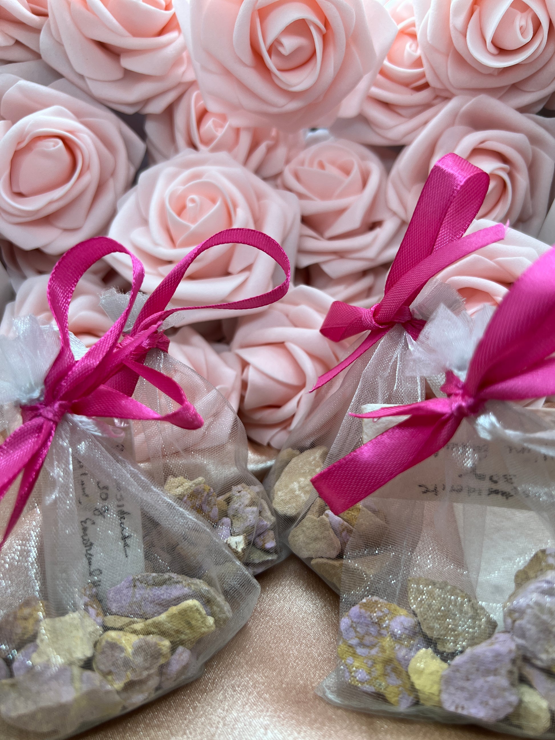 Pink roses with pink ribbons and decorative elements on a textured surface