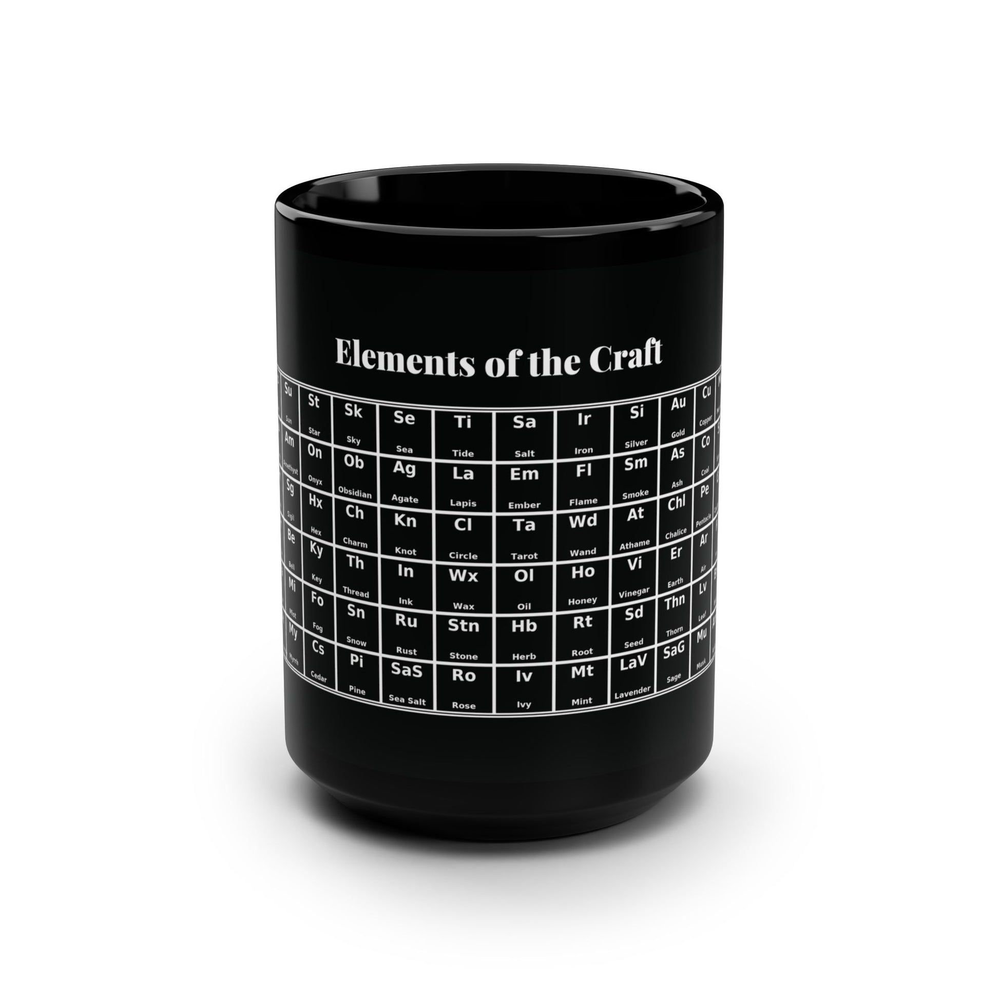Black ceramic coffee mug with a large handle, shown on a white background. A white “periodic table” style graphic is printed on the side, labeled “Elements,” with grid squares for witchy terms like moon, sun, quartz, amethyst, sigil, hex, key, water, mist, fog, frankincense, myrrh, and cedar.