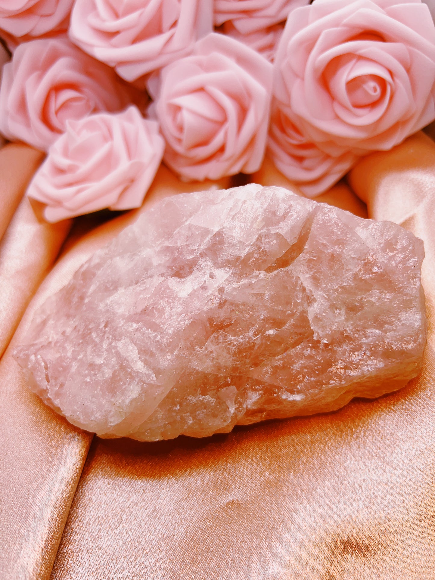 Crystal rock on a pink fabric background with pink roses